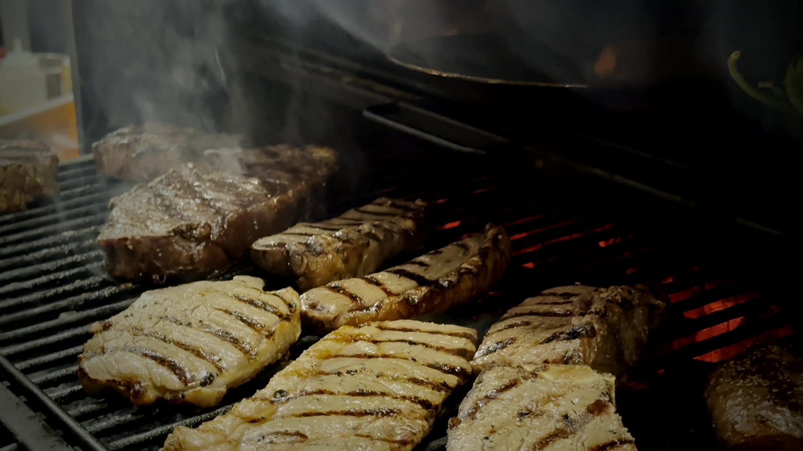 The asado fire at Renzo's — where the family-style grill platters for private events in Carrollwood are cooked